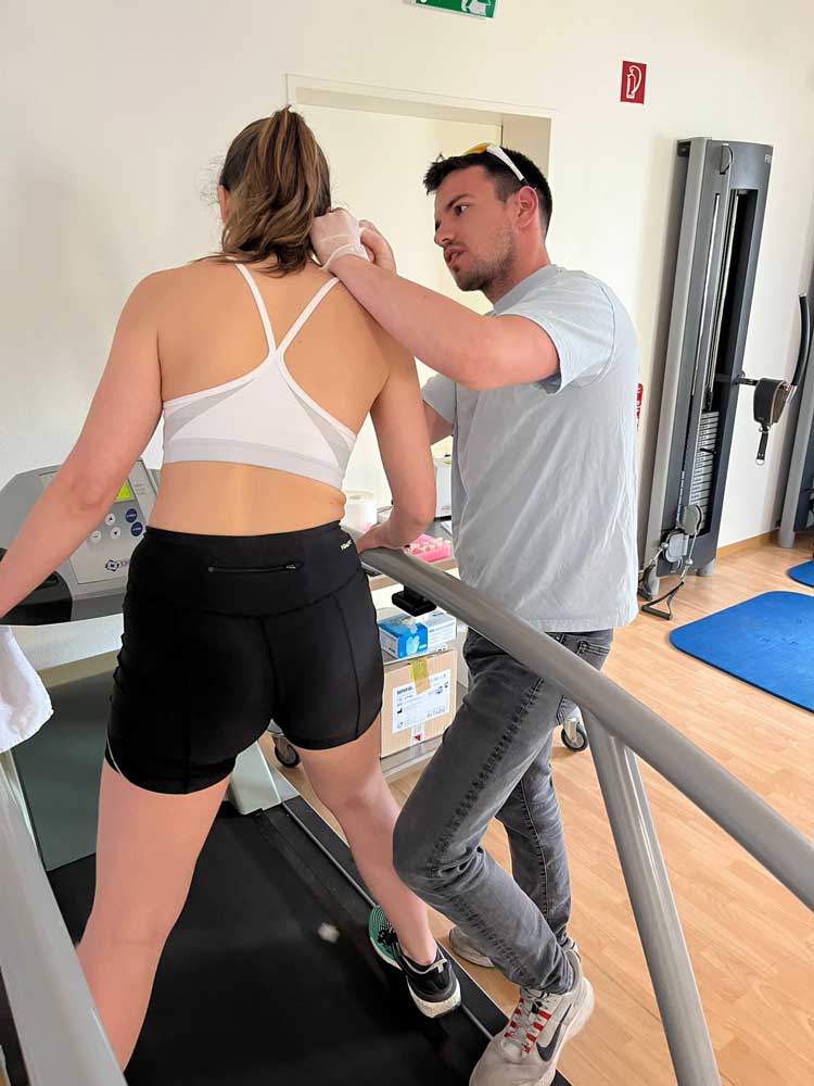 Ein Physiotherapeut von Physioeffekt misst den Laktatwert einer Patientin, die auf dem Laufband steht